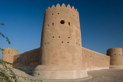 Low angle view of old ruins against clear blue sky