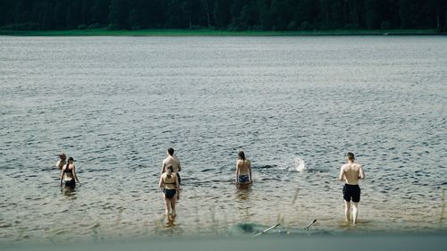 Rear view of people enjoying at beach