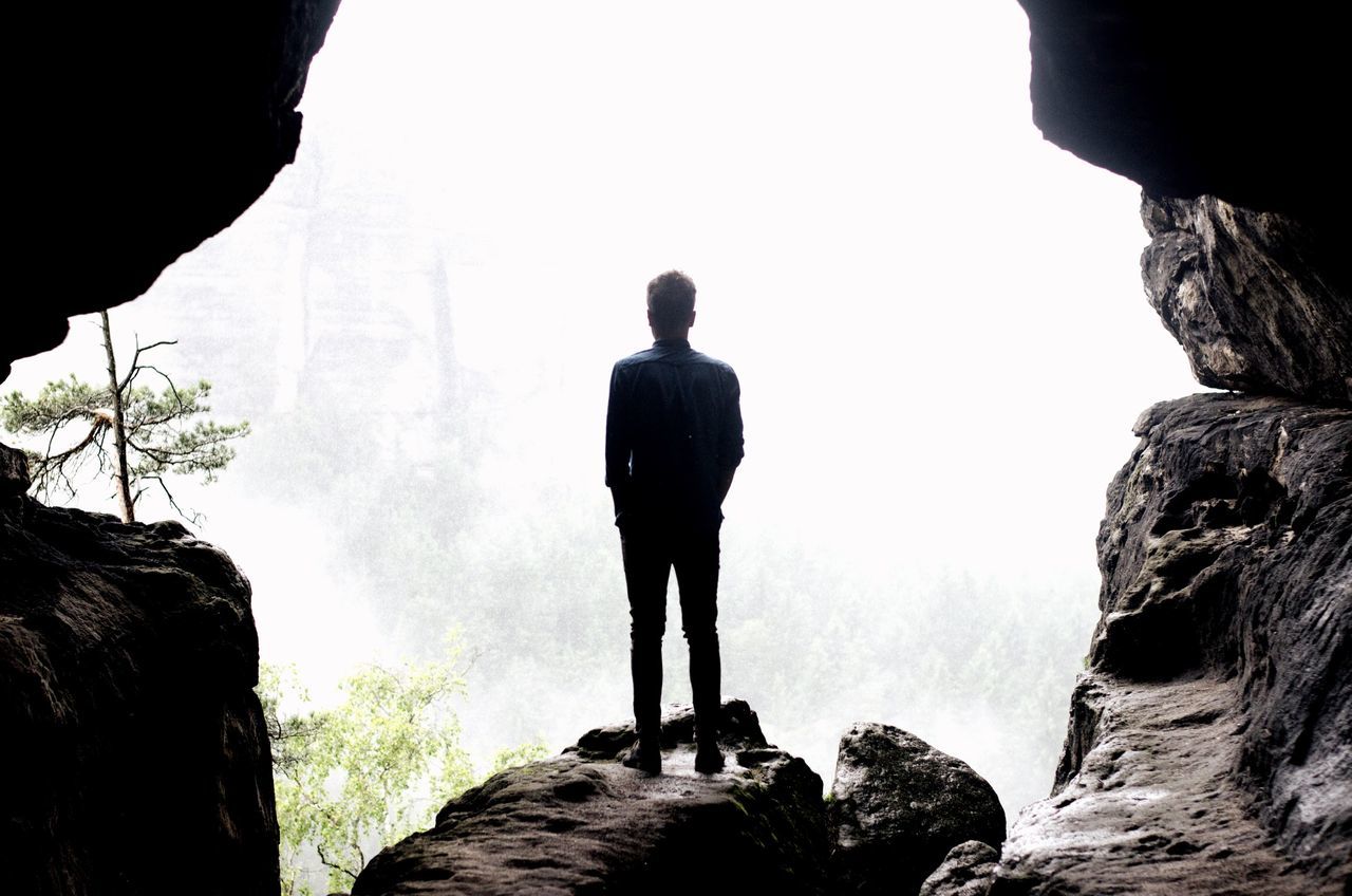 rock - object, lifestyles, men, rock formation, leisure activity, standing, rear view, clear sky, full length, tranquility, cliff, rock, tranquil scene, scenics, nature, mountain, beauty in nature, looking at view