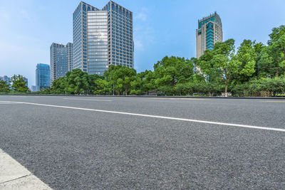 Surface level of road by buildings against sky