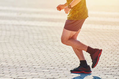 Low section of man running on road