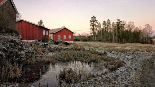 Houses by trees and buildings against sky