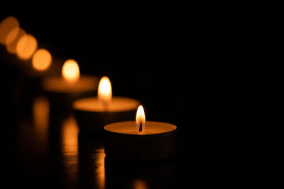 Close-up of lit candles on table