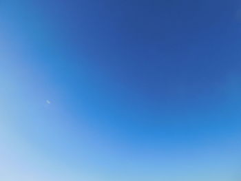 Low angle view of moon against clear blue sky