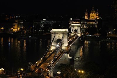 Illuminated bridge over river at night