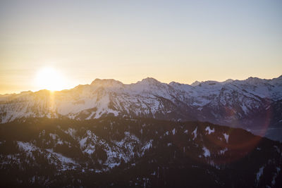 Scenic view of snowcapped mountains against sky during sunset