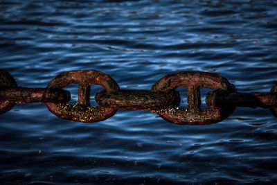 High angle view of rusty chain against river