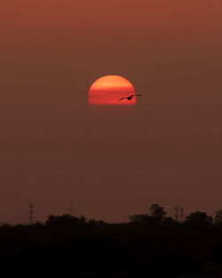 Silhouette of hot air balloon against orange sky