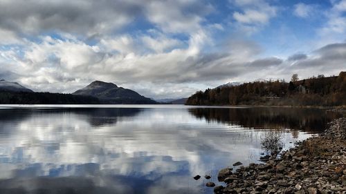 Scenic view of lake by mountains against sky