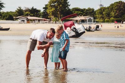 Father talking with son and daughter at beach