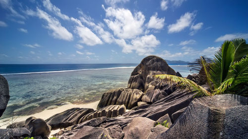 Scenic view of rocks on beach against sky