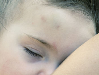 Cropped hand of mother with sleeping toddler daughter