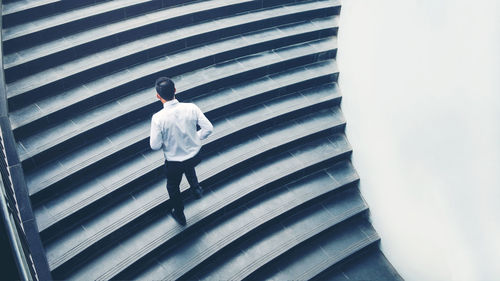 High angle view of businessman moving up on steps