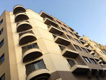 Low angle view of office building against clear blue sky