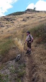 Full length of man standing on landscape against sky