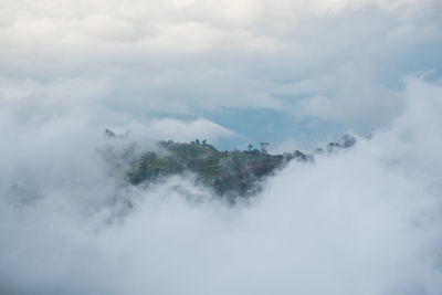 Scenic view of clouds covering mountains against sky