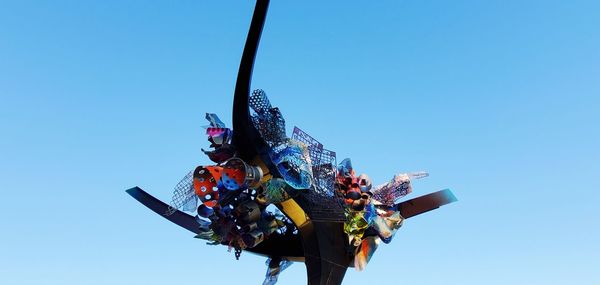 Low angle view of ferris wheel against clear blue sky