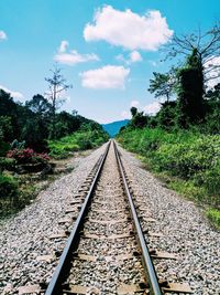 Railway tracks on landscape against sky