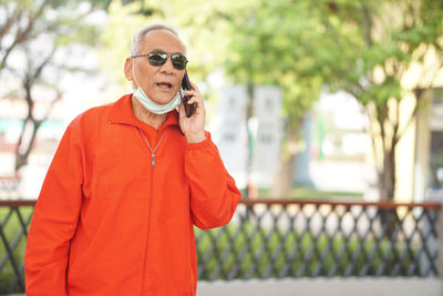 Young man using smart phone while standing on camera