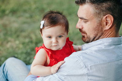 Middle age caucasian proud father holding baby daughter. family dad and daughter sitting together 