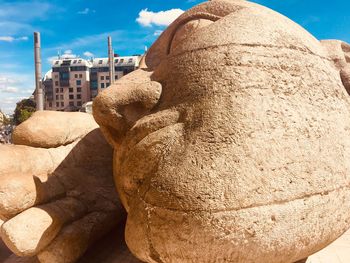 Close-up of statue by rock against building
