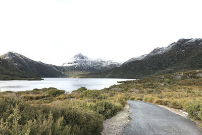 Road by lake against clear sky