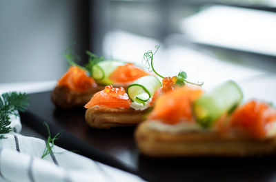 Eclairs with salmon, fresh vegetables and herbs, gourmet snacks.