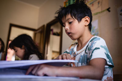 Sitting at kitchen table children doing homework at home