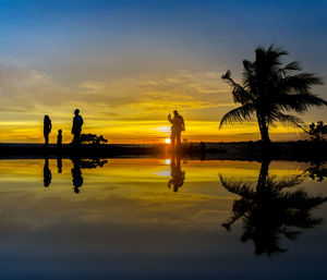 Silhouette people with reflections in water