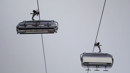 Low angle view of overhead cable car against sky