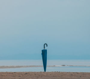 Umbrella standing against clear sky on beach