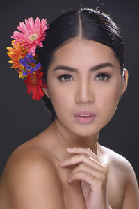 Portrait of beautiful young woman against black background