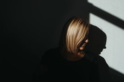 Portrait of woman standing against wall