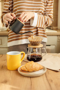 Midsection of woman using mobile phone on table