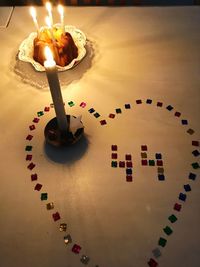 High angle view of illuminated candles on table