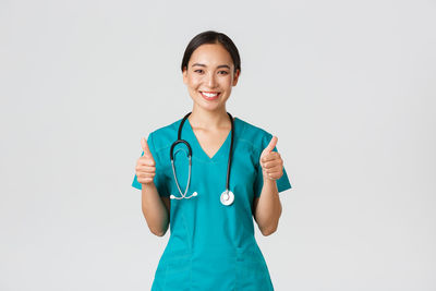 Portrait of a smiling young woman against white background