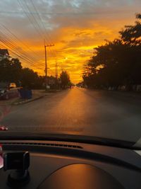 Road seen through car windshield during sunset