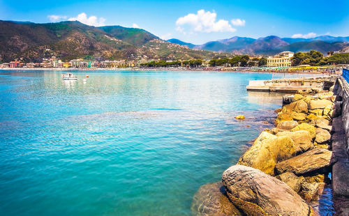 Scenic view of lake by mountains against blue sky