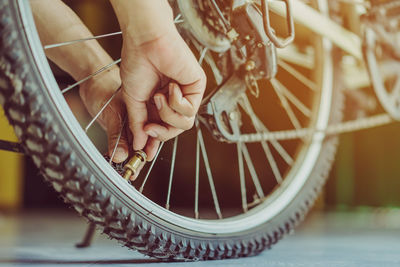 Cropped hands of person fixing bicycle tire 