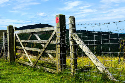 Fence on field against sky