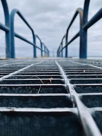 Close-up of metal grate against sky