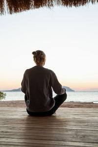 Health and wellness. young healthy woman practicing yoga and meditation on the beach at sunset