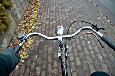 Midsection of person riding bicycle on road