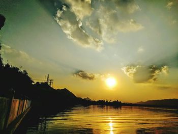 Scenic view of river against sky at sunset