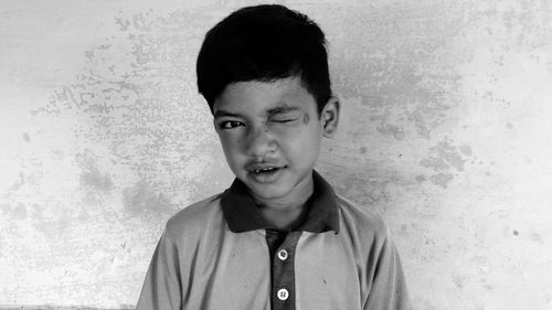 Portrait of young man standing against wall