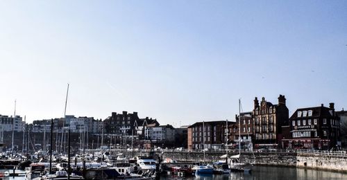 Sailboats in harbor against buildings in city