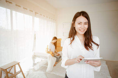 Portrait of smiling woman using digital tablet