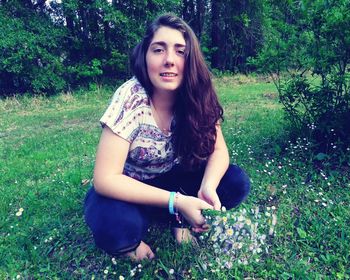 Portrait of smiling young woman sitting on grass