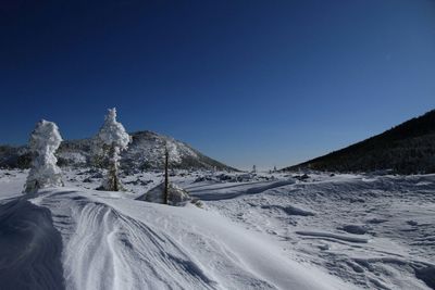 Scenic view of mountains against clear blue sky