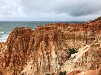 Rock formations in sea against sky